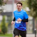 Blodin Selimi running in a blue race shirt with a bib